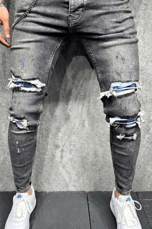 Spodnie jeansowe męskie szare rurki z dziurami w kolanach i plamami farby oraz łańcuchem